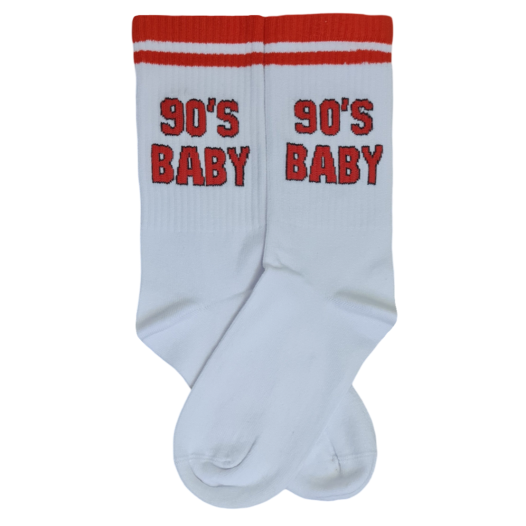 A pair of white socks with the text '90's BABY' printed in red and black on the side.