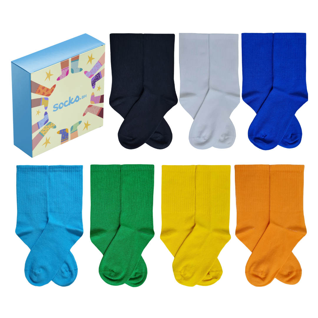 7 pairs of colorful crew socks in a white gift box including navy, grey, blue, light blue, green, yellow, and orange.