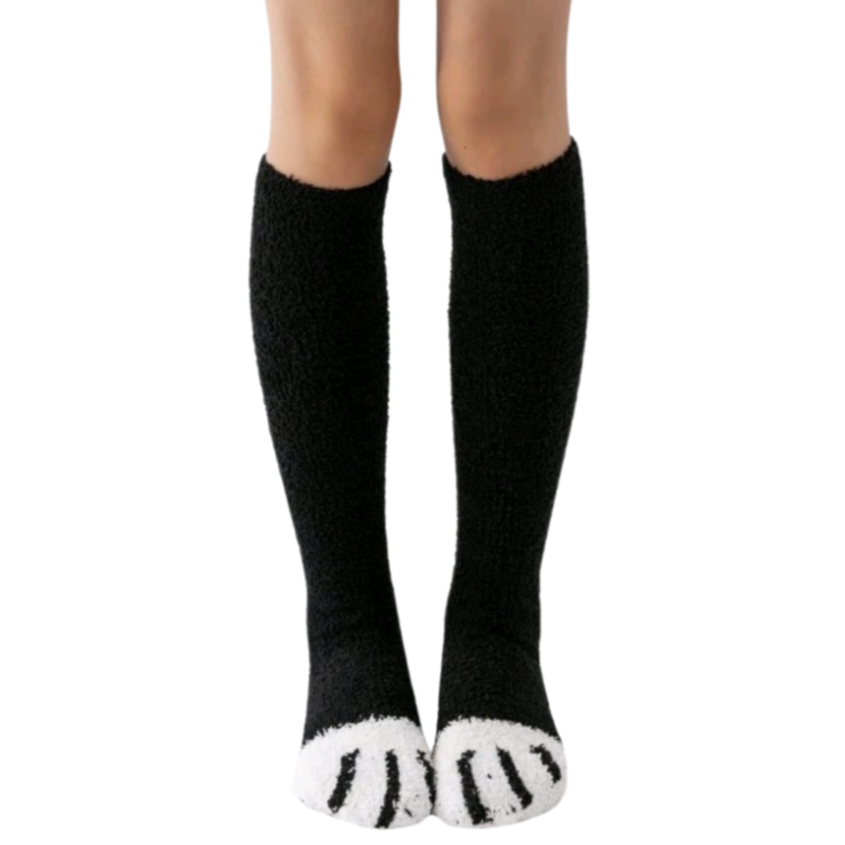 Black knee-high socks with white paw prints worn by a person on a white background