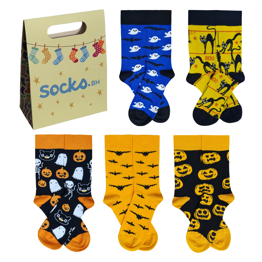 A Halloween-themed set of 5 pairs of colorful socks featuring ghosts, bats, pumpkins, skeletons, and black cats, presented next to a beige Socko.bh gift bag.