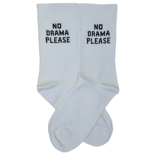 A pair of white cotton ribbed crew socks with bold black block letters reading "NO DRAMA PLEASE" on the ankle cuffs, displayed over a clean white background.