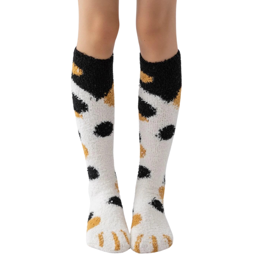 White socks with black and orange paw prints worn by a person on a white background