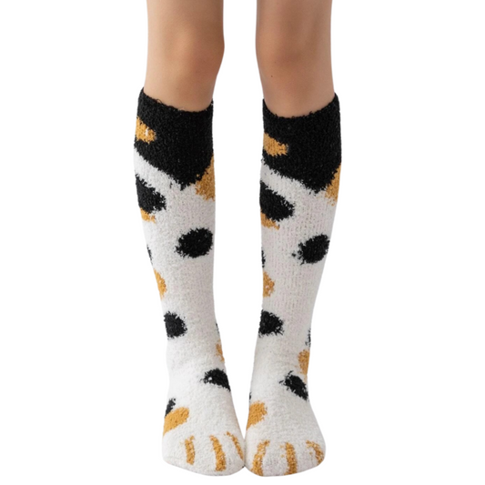 White socks with black and orange paw prints worn by a person on a white background