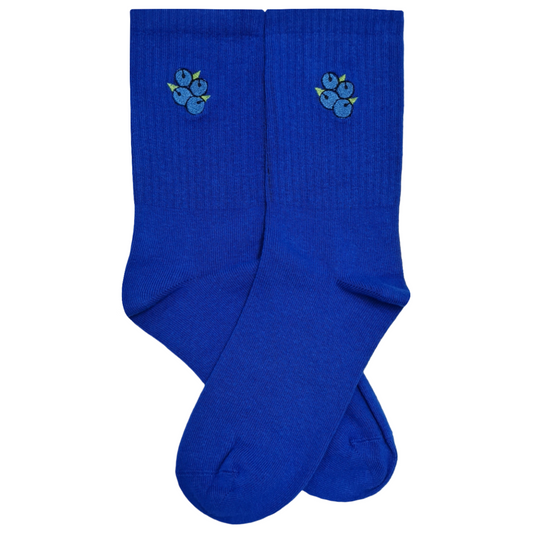 A pair of royal blue crew socks featuring a small, detailed embroidered blueberry cluster near the top cuff, set against a clean white background.