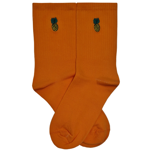 A pair of bright orange crew-length socks featuring a small, detailed pineapple embroidery near the cuff, displayed against a white background.