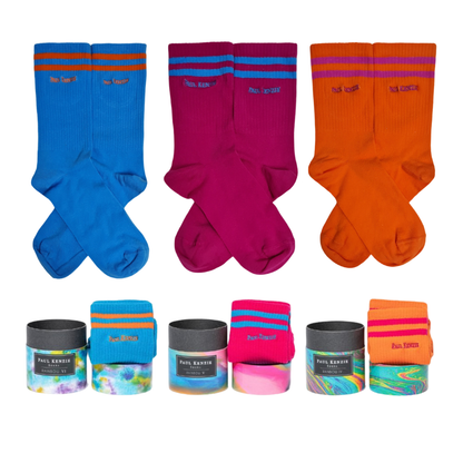 A 3-pack ribbed crew sock set featuring blue, magenta, and orange socks with contrasting double stripes at the top, shown with cylindrical gift boxes.