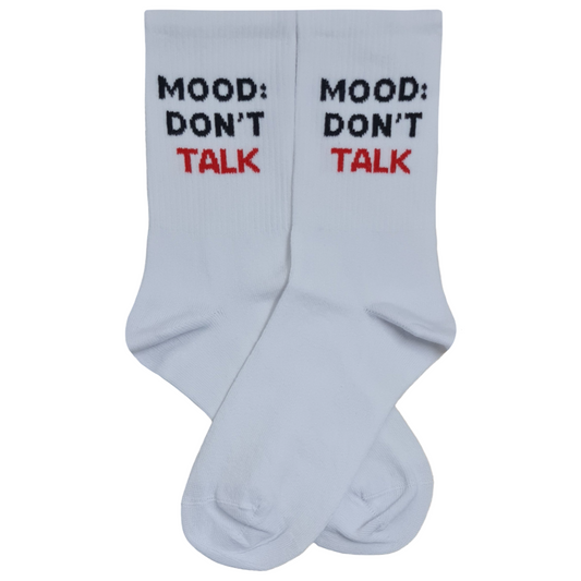 A pair of white crew socks laid flat against a white background, featuring the text "MOOD: DON'T TALK" knitted in bold black and red letters near the cuffs.
