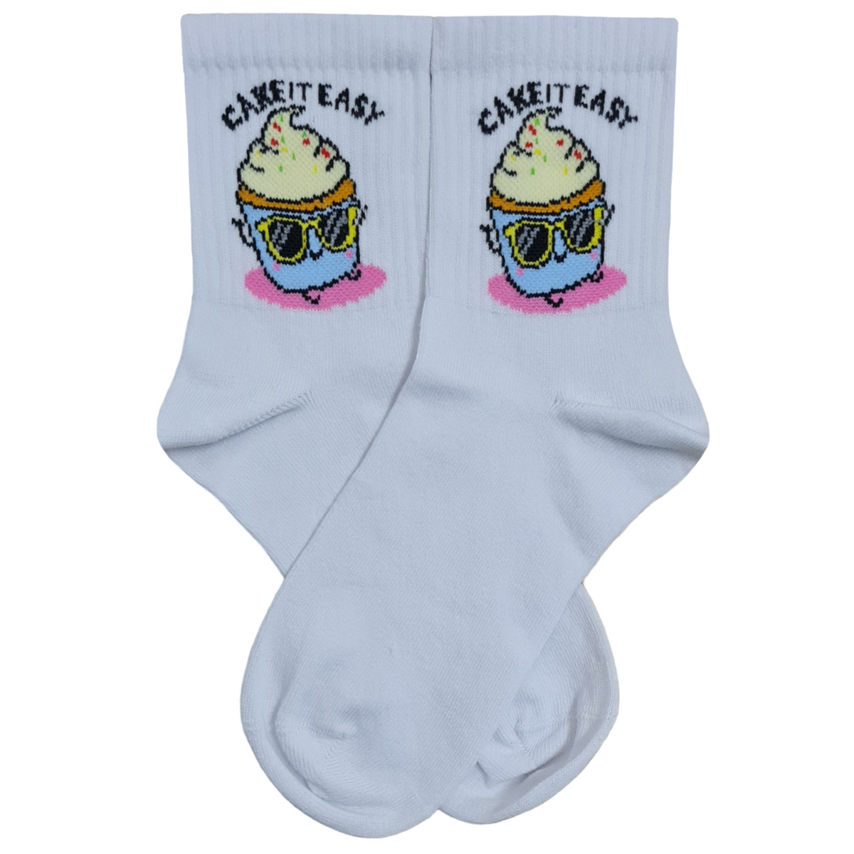 A pair of white quarter crew socks featuring a cartoon cupcake wearing sunglasses with the text Cake It Easy printed above it.