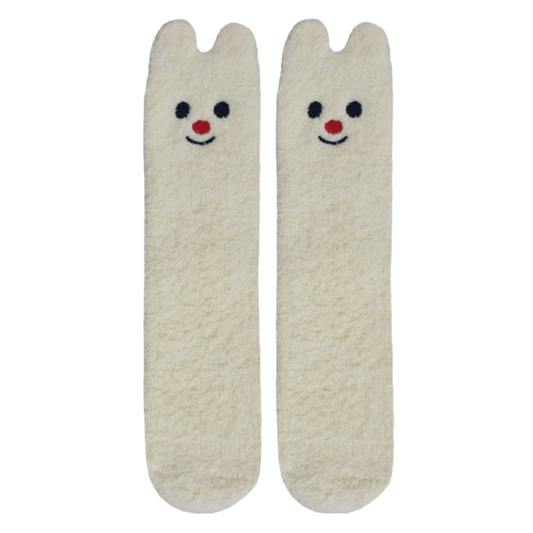 A pair of yellow, fluffy socks with cartoon bear faces on the toes.