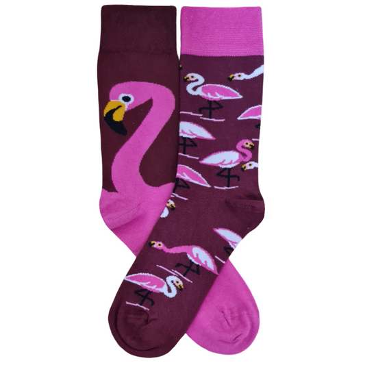 Mismatched flamingo crew socks featuring one large pink flamingo on a purple background and a matching pattern of smaller pink flamingos on the other sock.